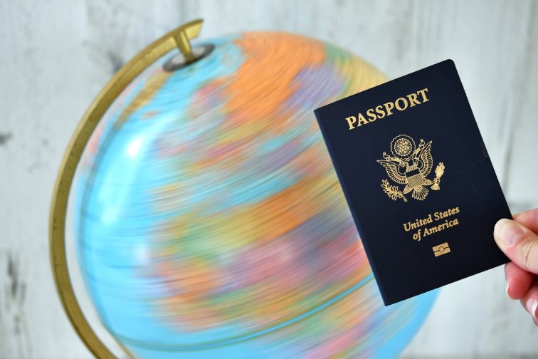 A United States passport with a spinning world globe in the background showing Europe, Asia, Africa